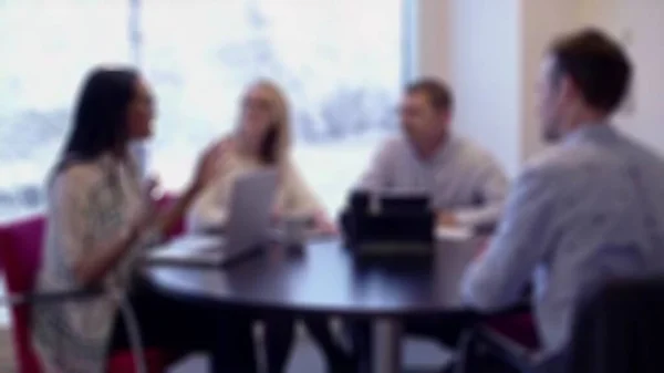 Blurry image of Beautiful african women manager giving direction to mixed race team of young guys. Creative business meeting at modern hipster office. Team leader and mixed race group people discussing start-up idea.