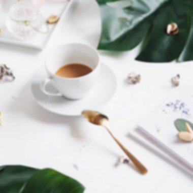 Tahta servis tepsisinin üzerinde düz kahve fincanı ve makrome süslemeli çiçek dalının bulanık görüntüsü. Bloglar ve sosyal medya için en az bohem yaşam tarzı kavramı