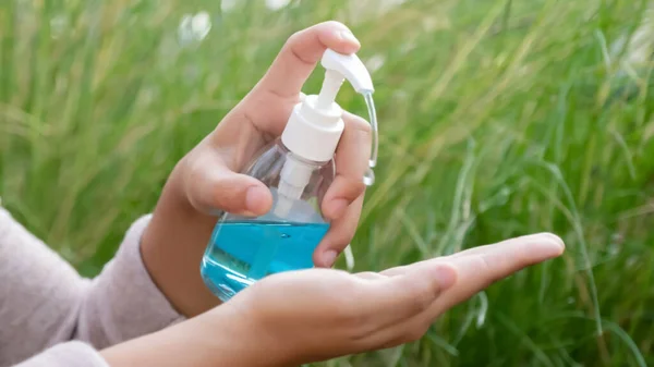 Female hands using hand sanitizer gel pump dispenser to protect from  gems.