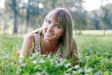 Genç kadın çimlerin üzerinde yatıyor.