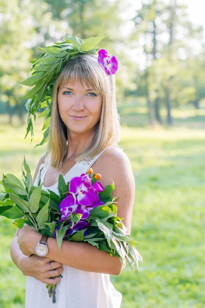 Jonge vrouw krans van bloemen en boeket dragen — Stockfoto