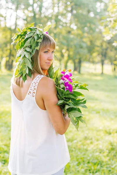 Młoda kobieta nosi Wieniec kwiatów i bukiet — Zdjęcie stockowe