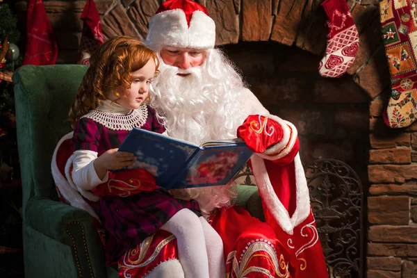 Papai Noel e menina leitura livro — Fotografia de Stock