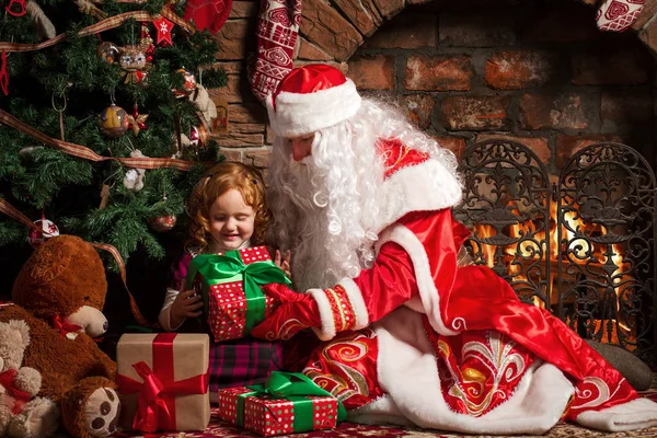 Grootvader Frost geeft een geschenk een klein meisje. — Stockfoto