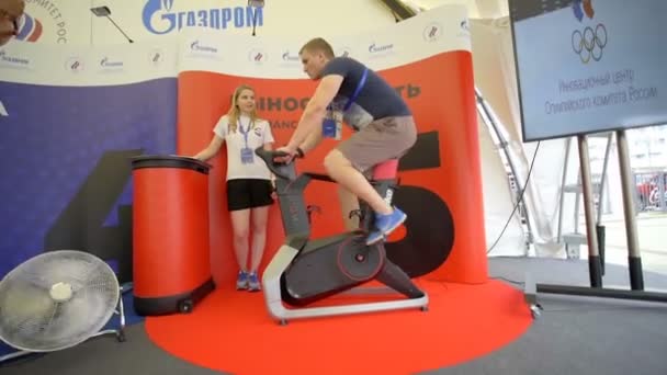 Misk, Belarus - June 21, 2019 젊은 남자가 강사에 의해 감독하는 운동 자전거 시험을 치른다 — 비디오