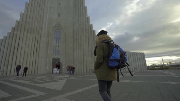 REYKJAVIK, ISLANDIA, 10 DE OCTUBRE DE 2019 Una niña entra en la iglesia luterana Hallgrimskirkja en Reikiavik — Vídeo de stock