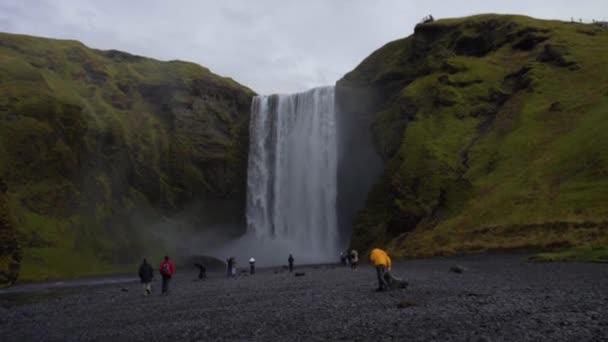 REYKJAVIK, ICELAND, OCTOBER 10, 2019 Huge Skogafoss waterfall.People come to the waterfall to make a photo on its background — Stock Video