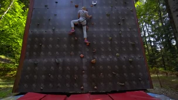 SILICHY, BELARUS - 2, AUGUST, 2019: Een meisje klimt tegen een muur om te klimmen — Stockvideo