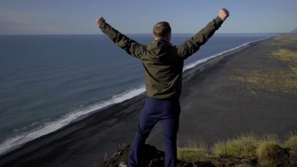 Le gars leva les mains pour célébrer une victoire au sommet de la montagne. Un homme regarde une vue magnifique — Video