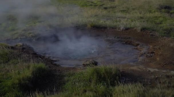 A água ferve em um pequeno gêiser. Vale verde com fontes termais — Vídeo de Stock