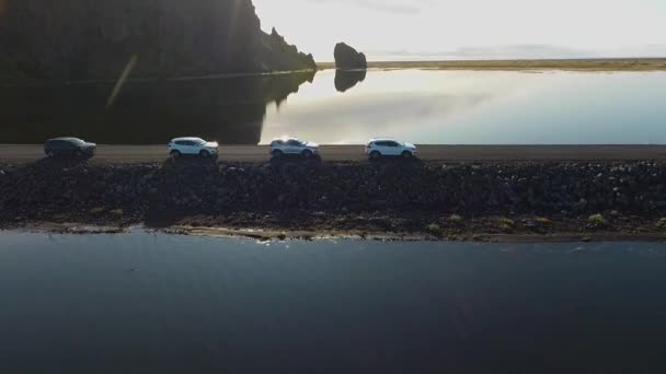 Flera bilar rör sig längs en väg omgiven av vatten på båda sidor — Stockvideo