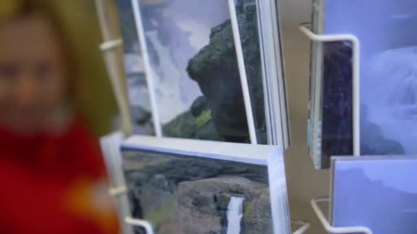 Support avec cartes postales. Cartes postales avec de beaux paysages de pays et les animaux tournent autour — Video