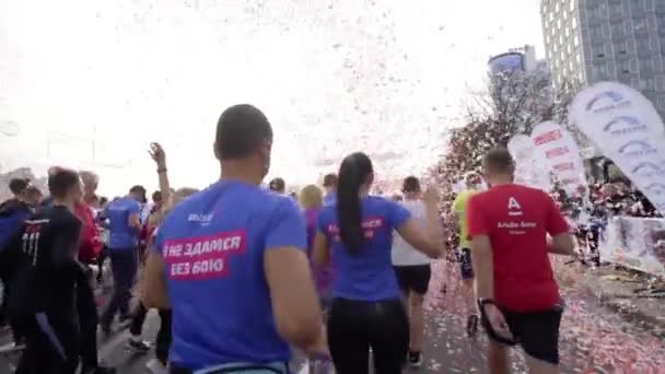 MINSK, BELARUS- SEPTEMBER 15, 2019: Gekleurde confetti stromen uit de lucht bij de atleten die eindigen Stockvideo