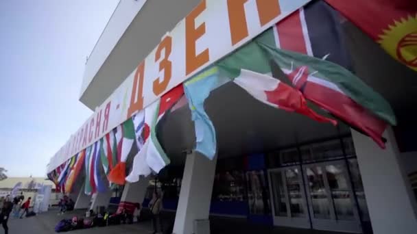 MINSK, BELARUS- 15. ZÁŘÍ 2019: Vlajky různých zemí vlály ve větru během sportovní události — Stock video