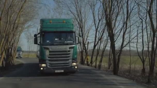MINSK, BELARUS- SEPTEMBER 10, 2018: Een Scania vrachtwagenkonvooi beweegt zich langs een landweg door een bos — Stockvideo