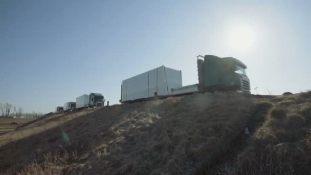 MINSK, BELARUS- SEPTEMBER 10, 2018: De groene vrachtwagen konvooi van Scania en MAN bewegen langs de snelweg, het blokkeren van de zon Stockvideo's