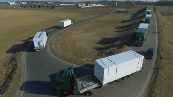 MINSK, BELARUS- SEPTEMBER 10, 2018: A large number of trucks with trailers make a turn and move from the bridge to the highway — Stock Video