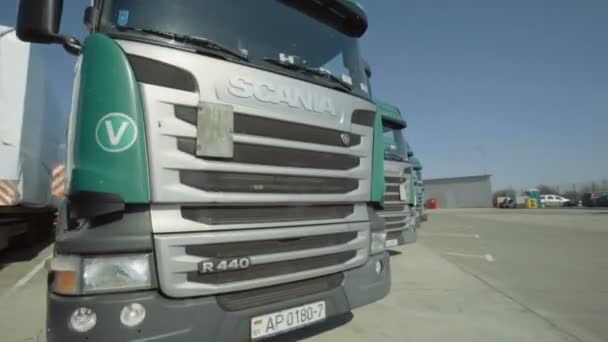 MINSK, BELARUS- SEPTEMBER 10, 2018: Bewegend shot van parallelle lijnen van de geparkeerde Scania en MAN groene truck. Chauffeurs lieten de vrachtwagens achter op de parkeerplaats. — Stockvideo