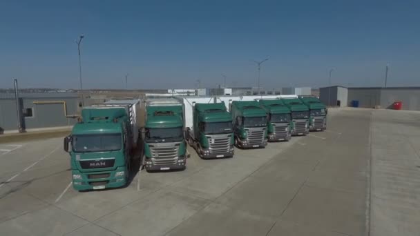 2018 년 9 월 10 일에 확인 함 . MINSK, BeliberUS- SEPTEMBER 2018: A line of green Scania and MAN truck are parked. 운전자들 이 주차장에 트럭을 두고 갔어요. 주차 된 트럭 주위를 날쌔게 비행 함 — 비디오