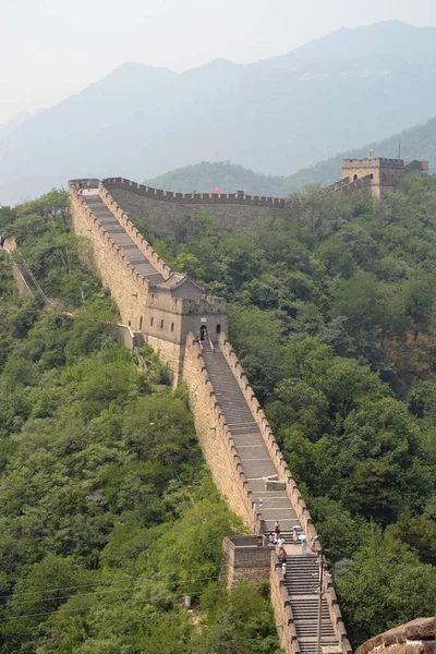 Büyük duvarın Mutianyu bölümünün merdivenleri arka planda yapraklı orman ve dağlarla çevrili büyük bir eşitsizliği koruyor. Pekin, Çin — Stok fotoğraf