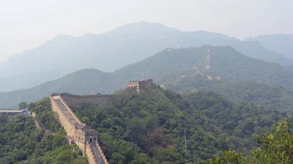 Yapraklı ormanlarla çevrili dağların arasında zikzak çizen büyük duvarın panoramik görüntüsü. Mutianyu bölümü, Pekin, Çin. — Stok fotoğraf