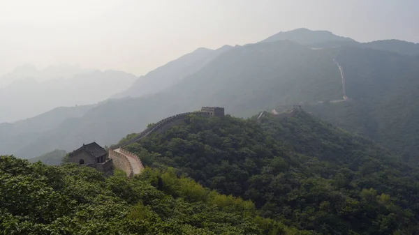 La gran pared que protege la frontera a través de las montañas rodeadas de bosque denso, sección de Mutianyu, Beijing, China . — Foto de Stock