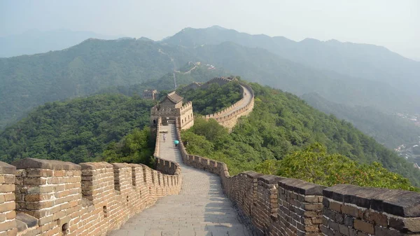 Camino de la gran muralla zigzagueando a través de la montaña y cruzando varios puestos de guardia. Vista desde el medio del camino. Sección Mutianyu, Pekín, China . Imágenes De Stock Sin Royalties Gratis