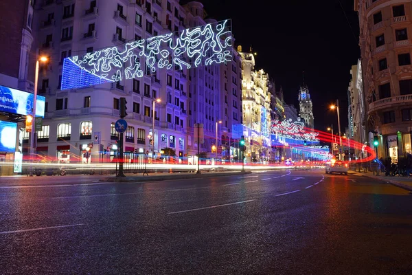 Gran vía calle por la noche decorada con luces de Navidad y un rastro de luz desde un taxi, Madrid, España — Foto de Stock