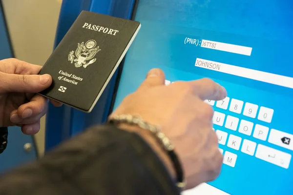 Ein Mann mit Reisepass und Bordkarte füllt die elektronische — Stockfoto