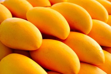 Close-up of Fresh Yellow Mangoes tropical fruits background or wallpaper. Fresh ripe exotic mango stack.  clipart