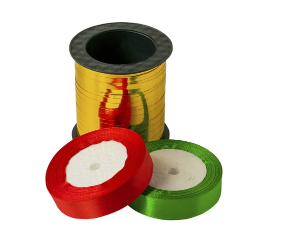 Roll of satin ribbon for decorating gifts on a white background. Silk and satin ribbon of gold, red and green