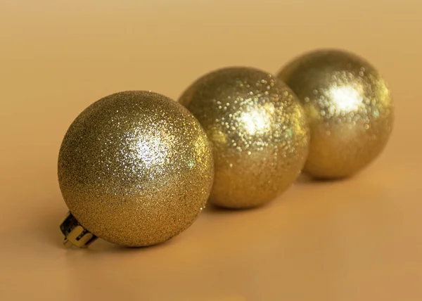 Gouden glanzend speelgoed in de vorm van een paraplu om de kerstboom voor het nieuwe jaar en Kerstmis op een oranje achtergrond te versieren. — Stockfoto