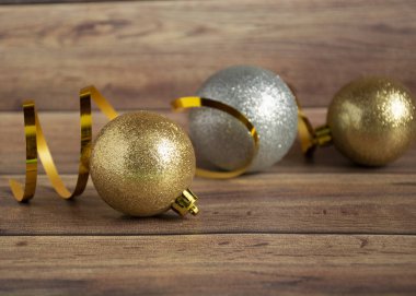 Altın ve gümüş Noel topları ve ahşap arka planda çok renkli çelenkler. Kopyalama alanı.