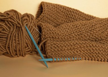 El işi ve el işi. Kahverengi iplikle örgü örmek. Bir ip yumağı. İğne işi.