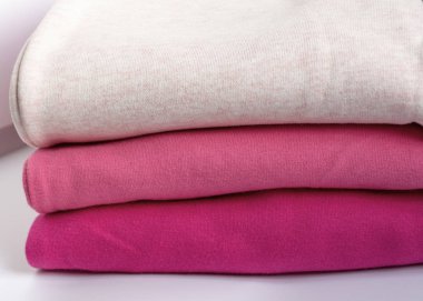 Tahta bir masanın üzerinde bir yığın kalın giysi. Giysiler istiflenmiş. Sıcacık kışlık sonbahar örgü giysileri