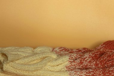 Turuncu arka planda bej ve turuncu örgü giysiler. Güzel örgü. Gradyan. Düz görünümü kopyala