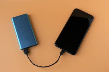 Mobil cihaz ve cihazları şarj etmek için güç bankası. Güç bankası olan mavi akıllı telefon şarj aleti. Kablosuz kulaklıklar ve hoparlörler için dış pil