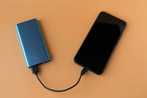 Powerbank zum Laden mobiler Geräte und Geräte. blaues Smartphone-Ladegerät mit Powerbank. externer Akku für drahtlose Kopfhörer und Lautsprecher — Stockfoto