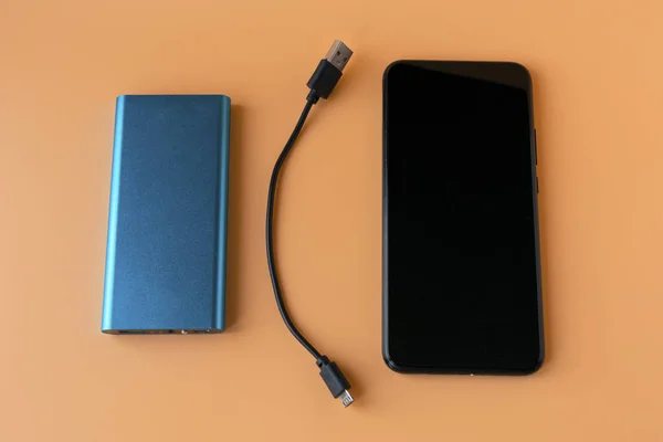 Powerbank zum Laden mobiler Geräte und Geräte. blaues Smartphone-Ladegerät mit Powerbank. externer Akku für drahtlose Kopfhörer und Lautsprecher — Stockfoto