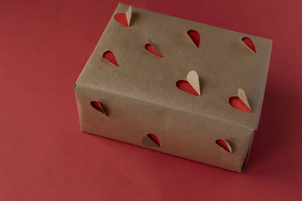 Regalo de bricolaje de papel kraft con un patrón de corazón y corazones rojos. Día de San Valentín. Día de San Valentín. Cumpleaños. Amor y corazón —  Fotos de Stock
