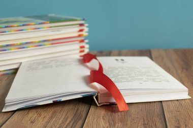 Sayfalar için yer imi olan açık bir kitap masanın üzerinde yatıyor. Kitap ciltleyici. Bilgi ve eğitim. Çocuklar için kitaplar.