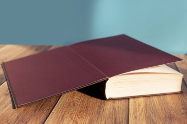 Masanın üzerinde açık bir kitap var. Sarı sayfalı bir yığın eski kitap. Kitap ciltleyici. Bilgi ve eğitim.