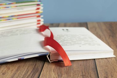 Sayfalar için yer imi olan açık bir kitap masanın üzerinde yatıyor. Kitap ciltleyici. Bilgi ve eğitim. Çocuklar için kitaplar.