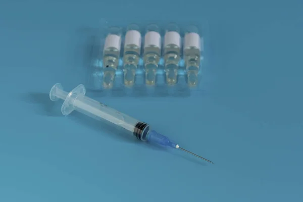 A bottle of medicine next to a syringe. Medicines for the virus and flu. Medical pills and antibiotics. Coronavirus, personal protective equipment, medicine with a syringe, vaccine and tablets — 스톡 사진
