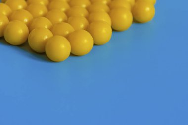 Mavi arka planda sarı vitaminler. Virüse karşı vitamin kompleksi. Sağlık ve bağışıklığı arttırmak için multivitaminler. Tıbbi konsept