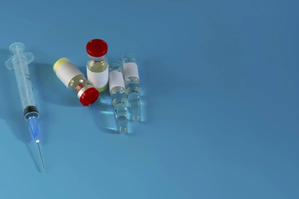 Egy üveg gyógyszer egy fecskendő mellett. Gyógyszerek a vírusra és influenzára. Gyógyszerek és antibiotikumok. Coronavirus, egyéni védőfelszerelés, fecskendős gyógyszer, vakcina és tabletta — Stock Fotó
