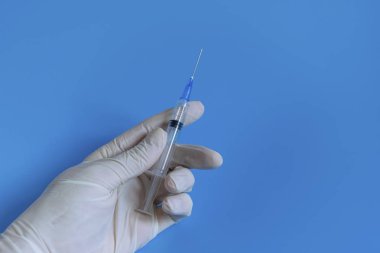 Tek kullanımlık beyaz eldivenler, aşılı şırınga ve ilaç. Hijyen ve virüslere karşı koruma. Coronavirüs