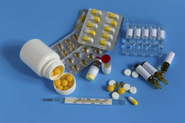 Egy üveg gyógyszer egy fecskendő mellett. Gyógyszerek a vírusra és influenzára. Antibiotikumok. Coronavirus, egyéni védőfelszerelés, eldobható orvosi maszk, fecskendős gyógyszerek, vakcina és tabletták — Stock Fotó
