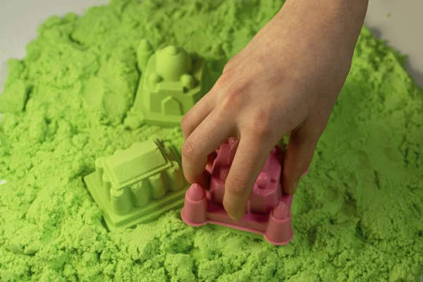 Kinetic sand. A child plays with kinetic sand. Fine motor skills, creativity, games