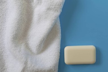 Mavi arka planda yumuşak ve kabarık havlular. Banyo, çamaşır ve vücut bakımı için sabun. Kişisel hijyen ürünleri. Banyo aksesuarları..